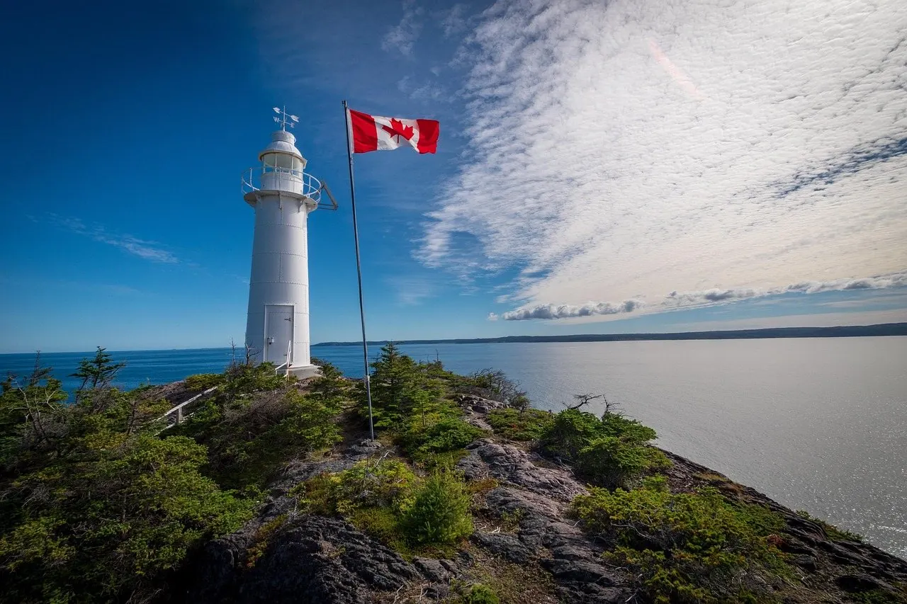 Canadian flag flying beside a lighthouse