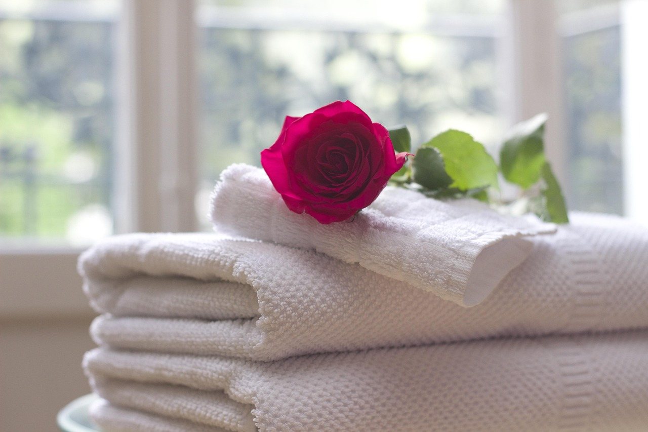 Folded hotel towels with a rose
