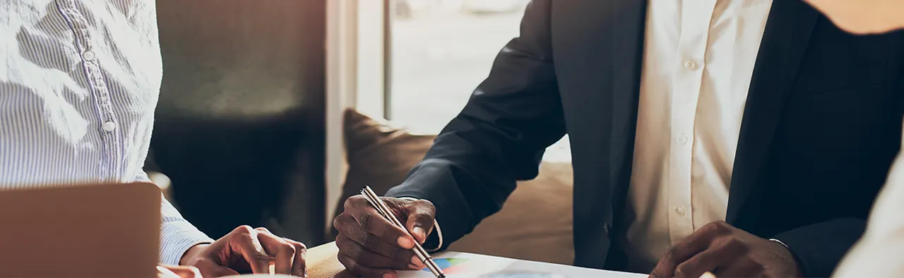 A professional handshake across a desk